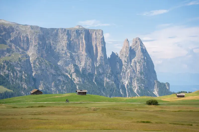 Wooden huts on the green Seiser Alm meadows with the Schlern massif behind
